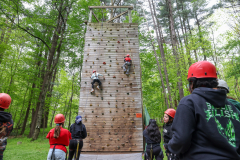 People at a rock climbing event in a wooded area.