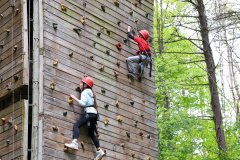 Two people climbing a rock wall at an indoor climbing facility.