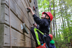 Person climbing a rock wall at camp.