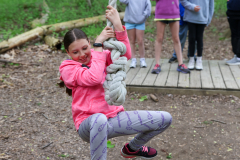 Girl swinging on a rope in a park.