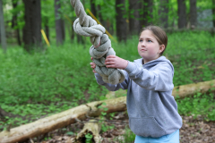Girl in a park holding a rope.