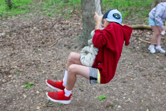 Person in red jacket swinging on a rope.
