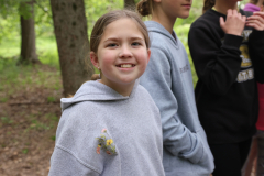 Girl in grey hoodie smiling at camera.
