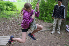Girl on a rope swing in a park.