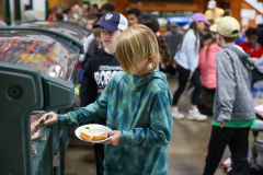 Two young boys looking at food in a cafeteria.