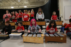 Students playing instruments in a concert band setting.