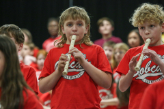 Two boys playing flutes in a school band.