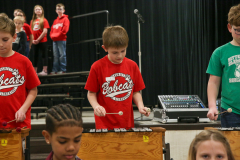 Young boys playing musical instruments in a school concert band.