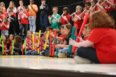 Group of children playing instruments on stage.