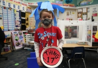 Young boy in a classroom setting wearing a Dr. Seuss mask.