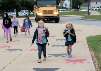 Children walking to school on a sidewalk.