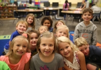 Children posing in a classroom on their first day of kindergarten.