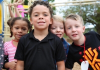 Children posing together for a first day of school picture.
