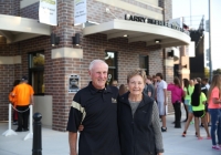 Older couple posing in front of a sports facility.