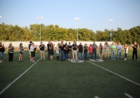 Group of people posing on a football field.