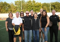 Group of people posing for a picture on a football field.