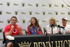 Three people sitting at a table with microphones, in front of a sign that reads "DENVER HILDEBRANDT PARADE".