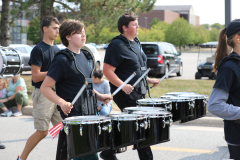 People marching in a parade, playing musical instruments.