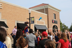 People gathered outside a building, watching an event.