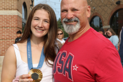 Sarah Hildebrandt poses with a gold medal around her neck, proudly displaying her achievement.