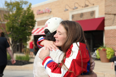 Two people hugging each other in a parking lot.